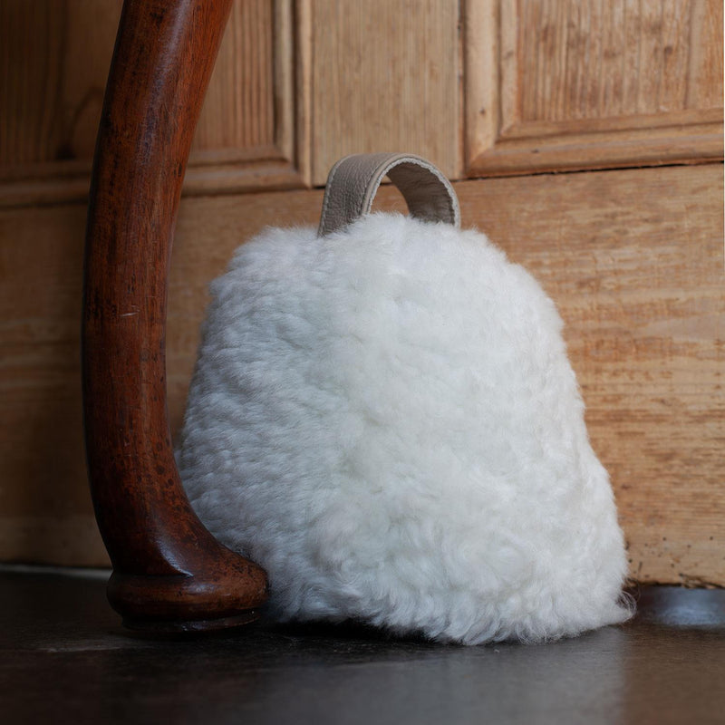 Sheepskin Doorstop in white curly sheepskin with ecru leather carry handle