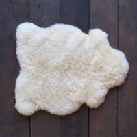 Soft, thick, & supportive British economy sheepskin pet bed or economical rug for the home or garden in natural creamy tones