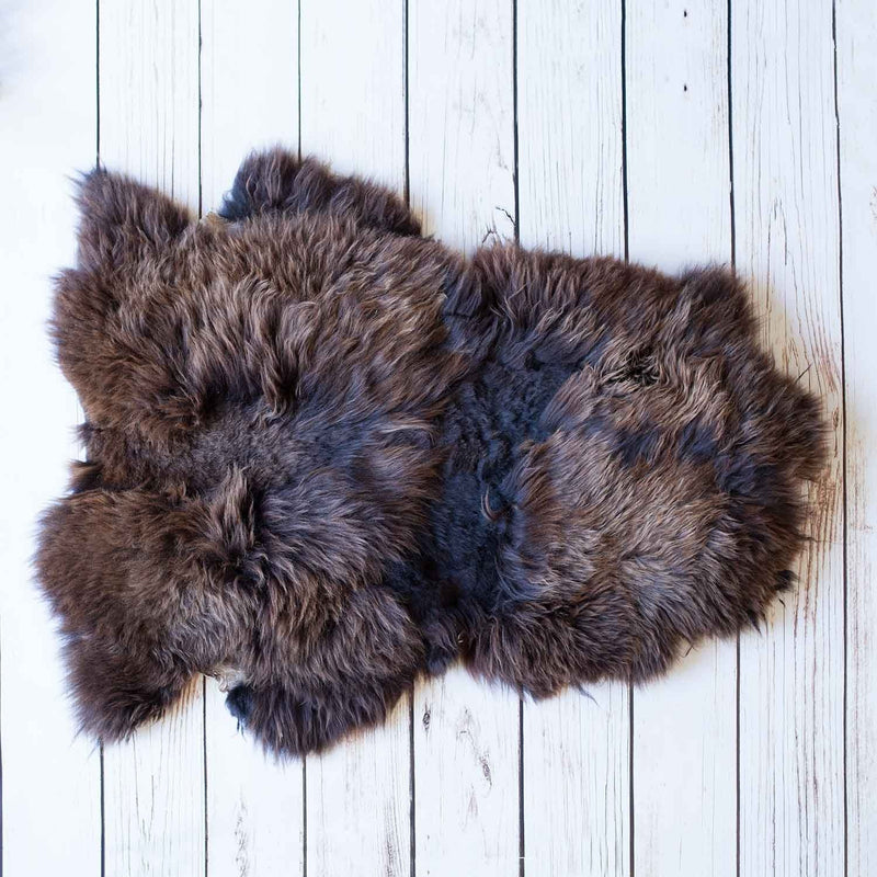 Soft, thick, & supportive British economy sheepskin pet bed or economical rug for the home or garden in chocolate brown tones